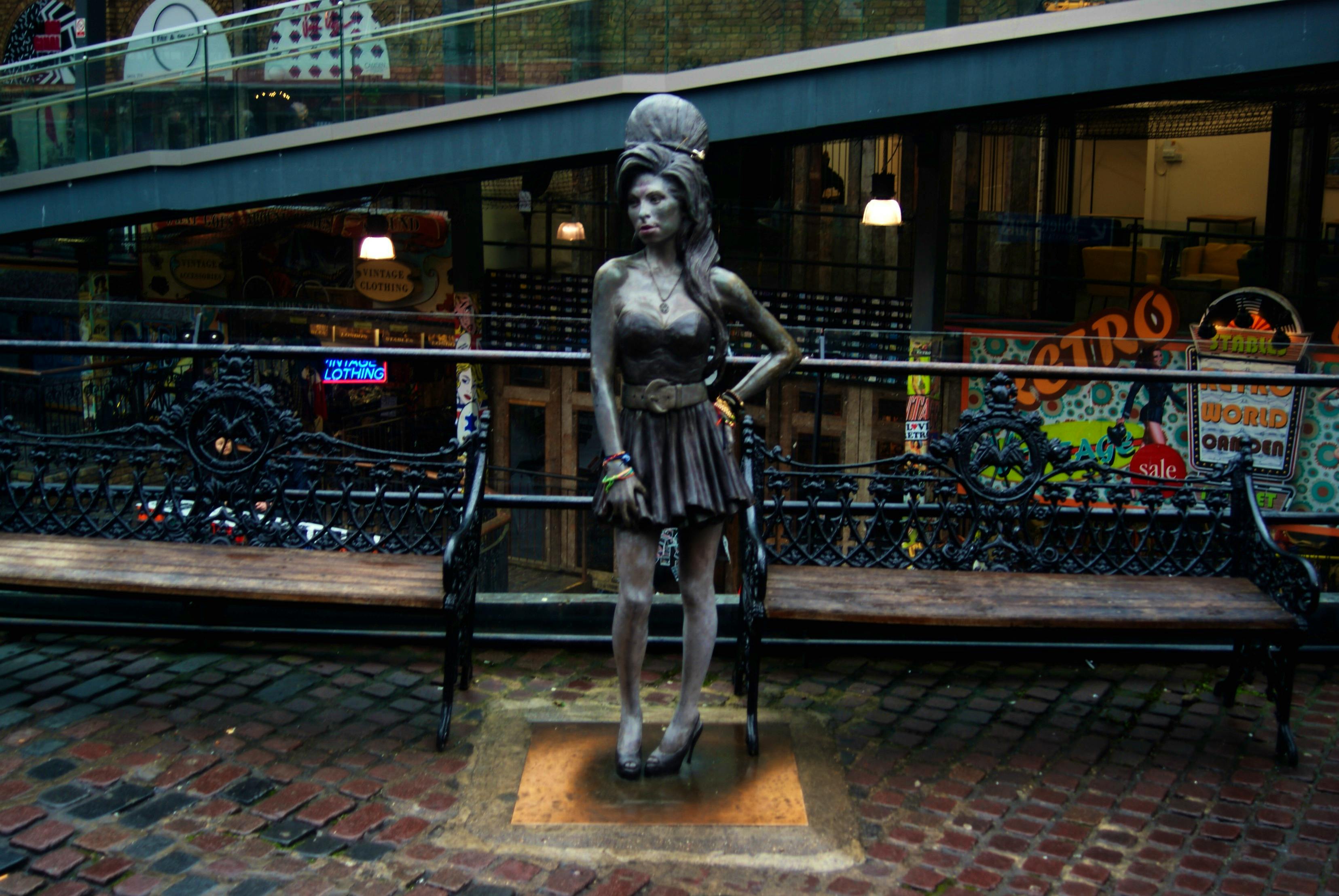   - View of the Amy Winehouse statue in the Camden Stables Market by Robert Lamb, CC BY-SA 2.0  via Wikimedia Commons